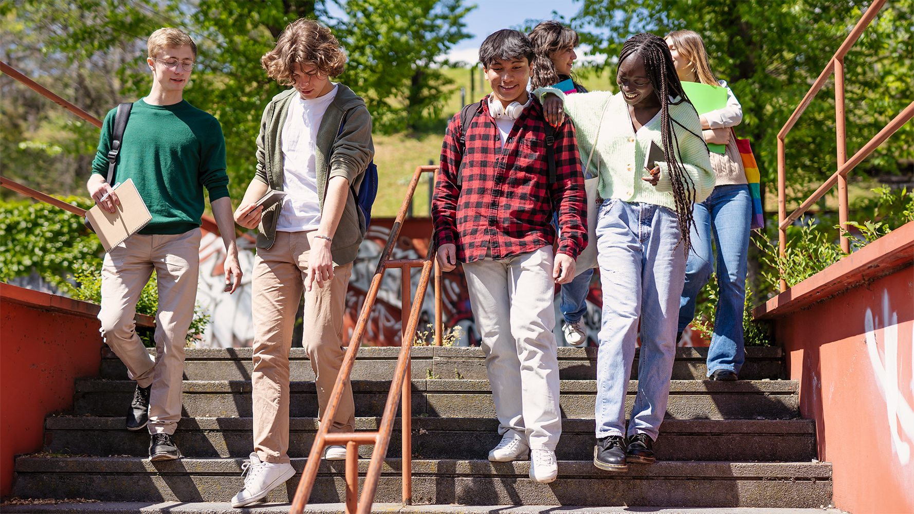 Austauschstudentinnen und -studenten steigen gut gelaunt eine Treppe hinunter