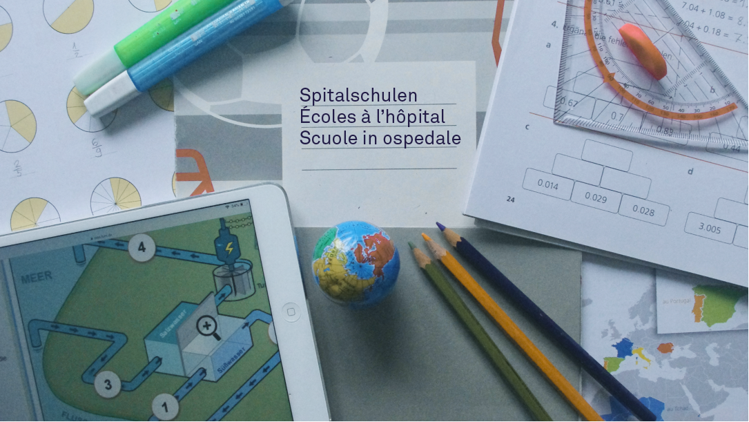 Diverses Schulmaterial liegt auf einem Tisch, ein Heft trägt die Beschriftung «Spitalschulen» in Deutsch, Französisch und Italienisch