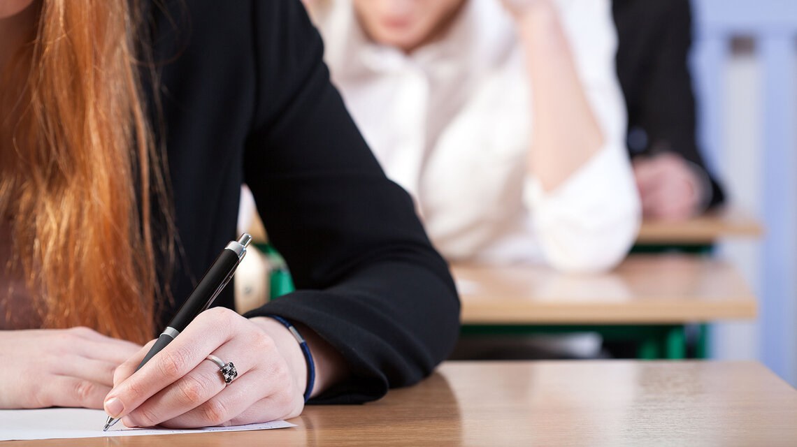 Une femme écrit dans un document sur un pupitre