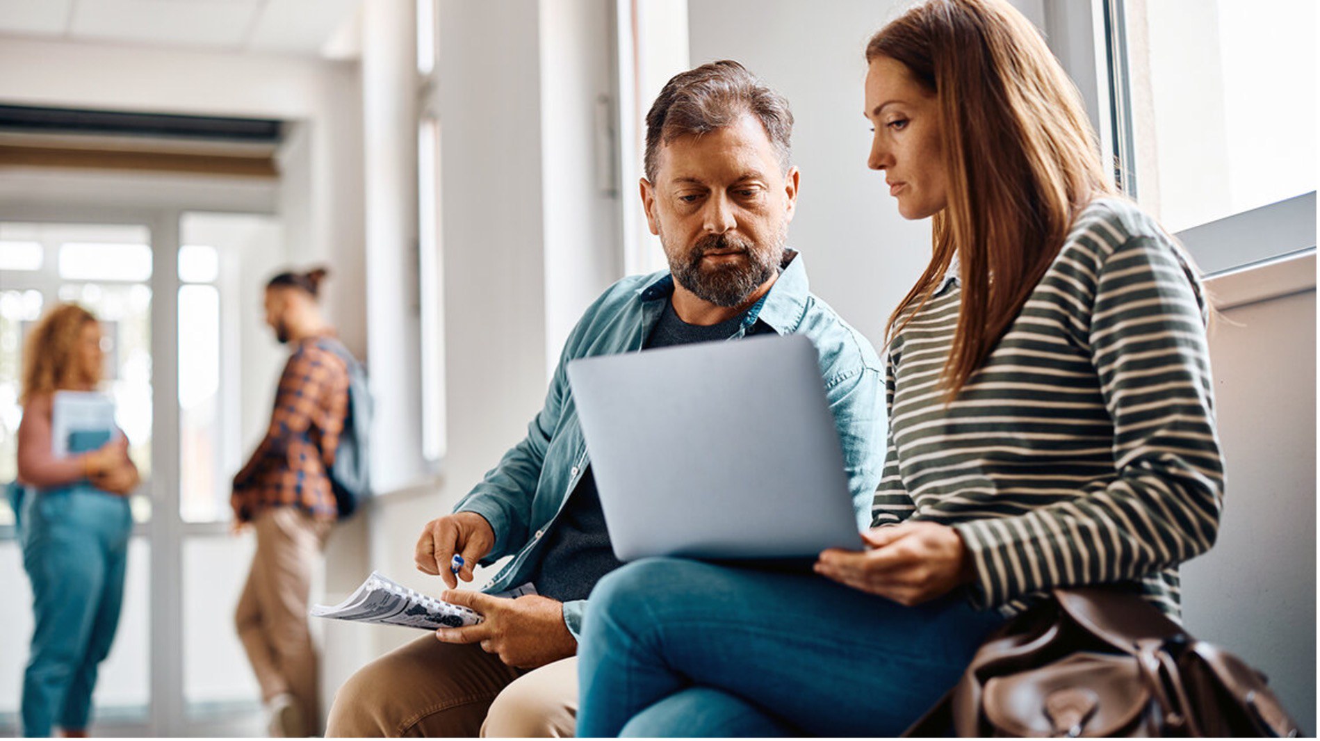 Un homme et une femme regardent sur un laptop