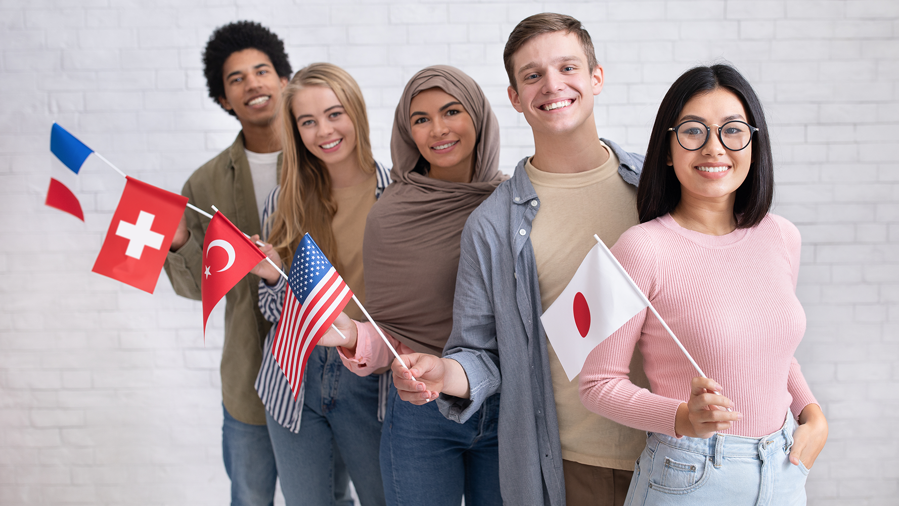 Cinq étudiants et étudiantes sont alignés et tiennent le drapeau de leur pays