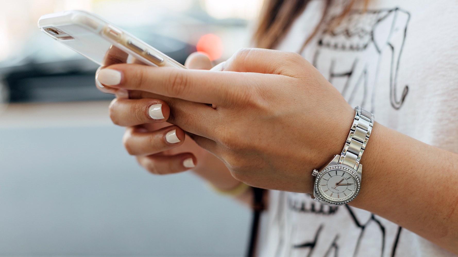 Hände eines Mädchens halten ein Smartphone und schreiben etwas